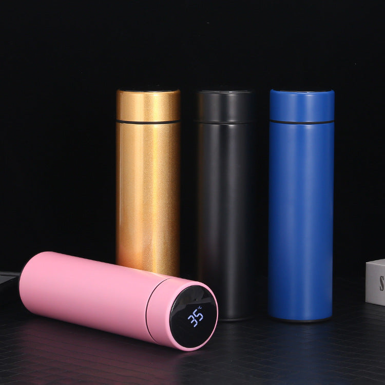Set of four insulated bottles in gold, black, blue, and pink with digital temperature display on a dark background.